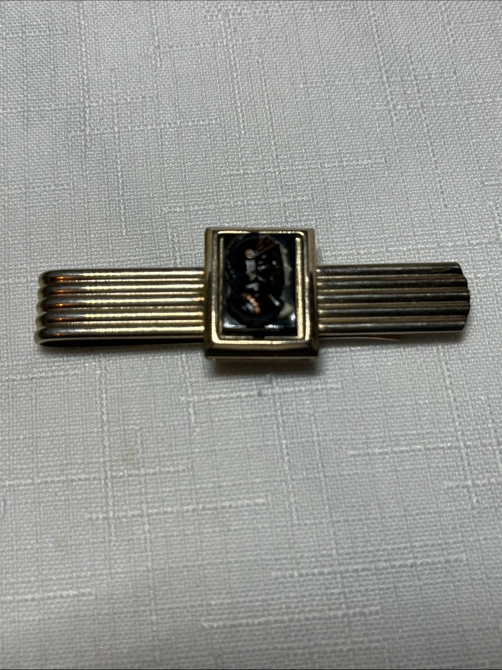 Vintage gold-tone metal tie clip featuring a rectangular center inlay